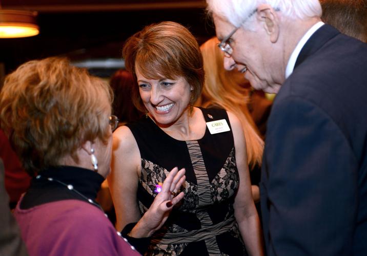 Janet Derrick (center) executive director of Naperville CARES, greets guests and supporters at the organization's eighth annual Toasting for a Cause at Sullivan's Steakhouse in Naperville.
